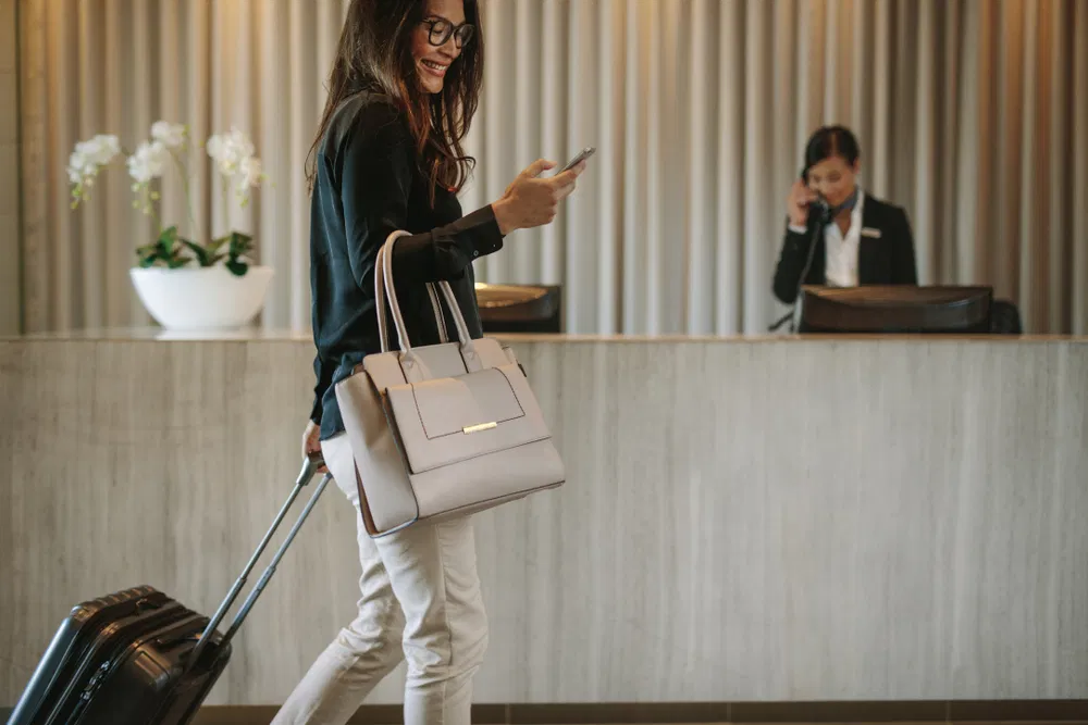Woman with suitcase walks through hotel