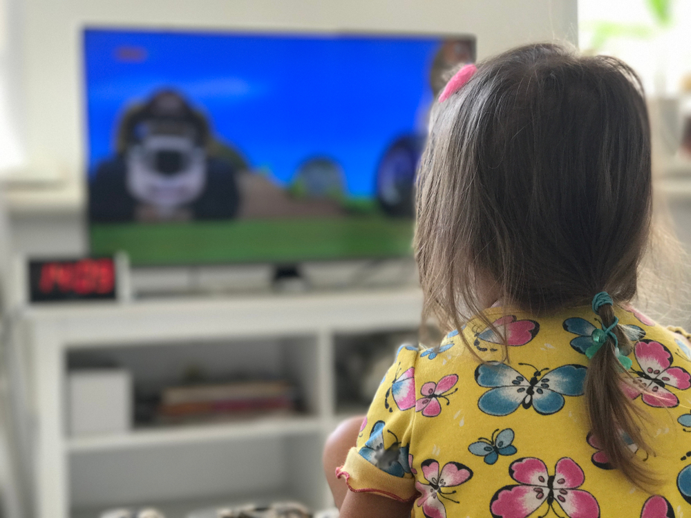 Girl watching english cartoon on TV
