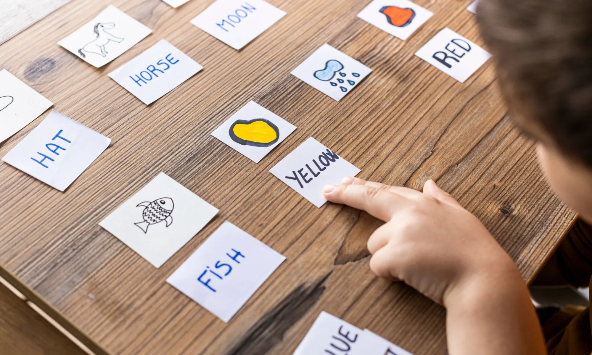 a Little kid playing with cards of words and pictures