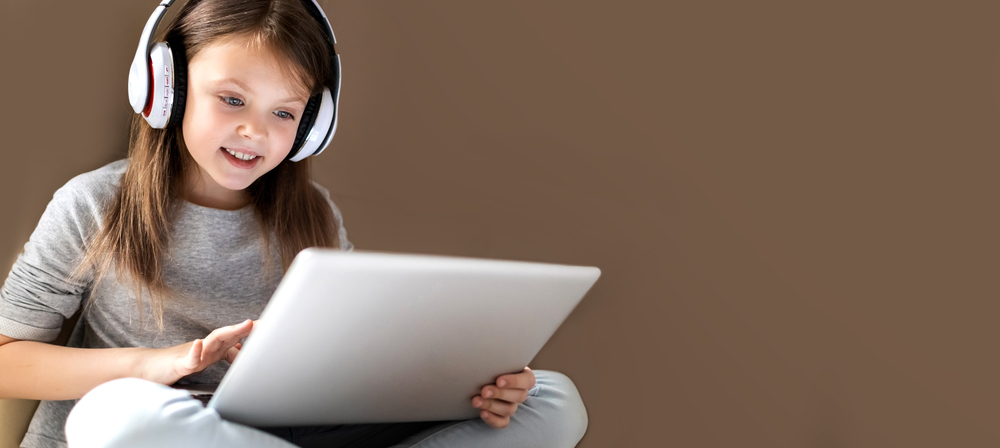 Girl wearing headphones with a laptop