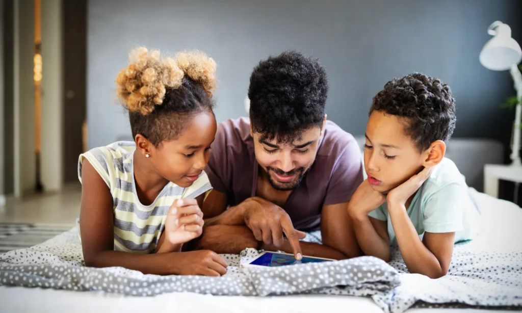 Kids playing educational vidego game with dad