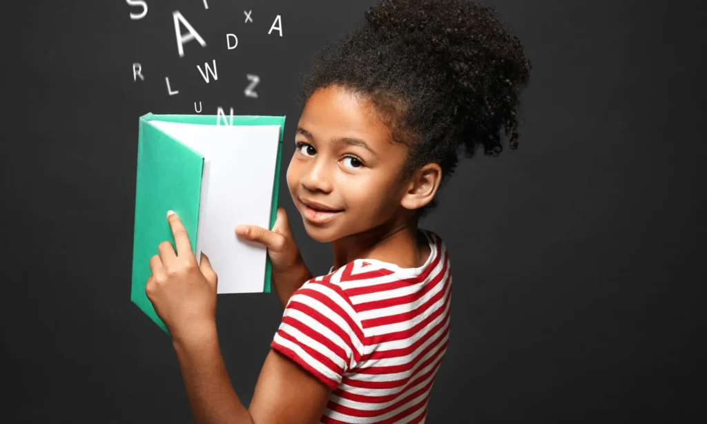 Afro-American girl with a book and letters of the alphabet