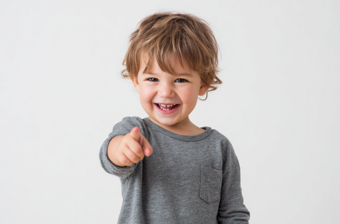 Un niño pequeño apuntando feliz con la mano